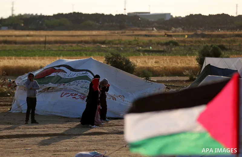 Palestinians sit next to a tent during tents protest demanding the right to return to their homeland, at the Israel-Gaza border in the east of Gaza city on April 23, 2018. Photo by Yasser Qudih