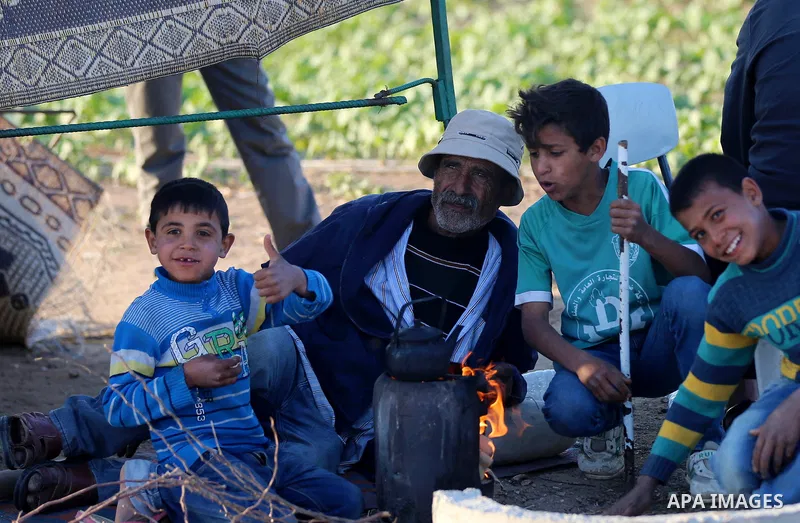 Palestinians prepare tea next to a tent during tents protest demanding the right to return to their homeland, at the Israel-Gaza border in the east of Gaza city on April 23, 2018. Photo by Yasser Qudih