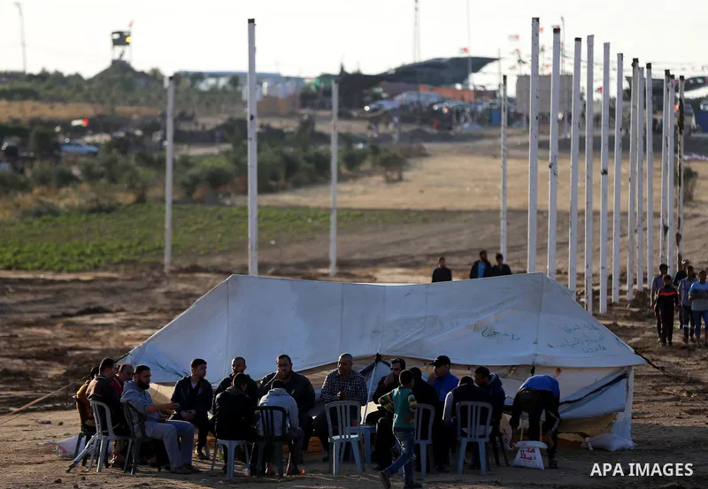 Palestinians sit next to a tent during tents protest demanding the right to return to their homeland, at the Israel-Gaza border in the east of Gaza city on April 23, 2018. Photo by Yasser Qudih