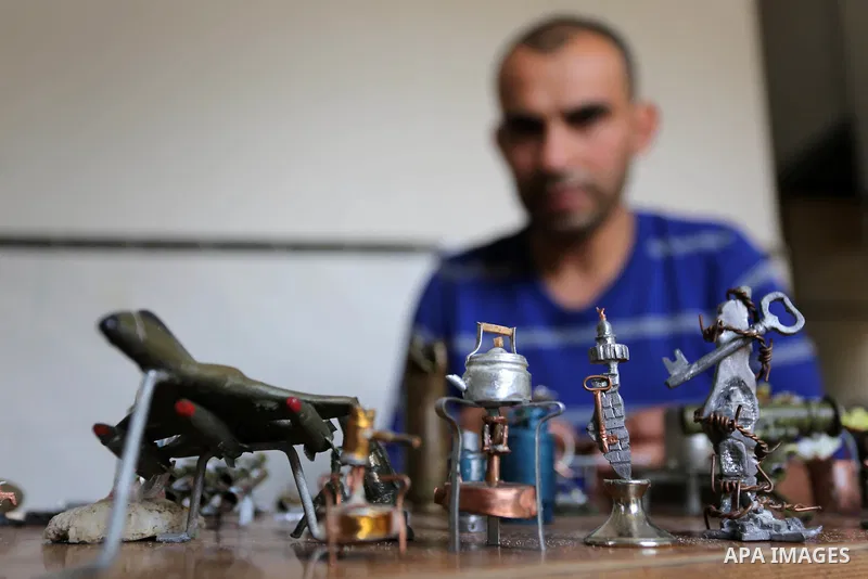 Palestinian artist Magdy Abu Takeya, 38, converts gunshots used by the Israeli security forces against Palestinian protesters to small pieces of art knows as "Art of thumbnails" at his house in Nuseirat in the central Ga...