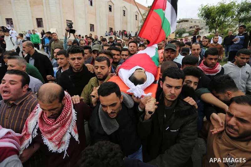 Mourners carry the body of Palestinian journalist Ahmed Abu Hussein, 24, who was died of his injuries sustained by Israeli security forces as he was covering demonstrations on the Gaza border since two weeks ago, during...