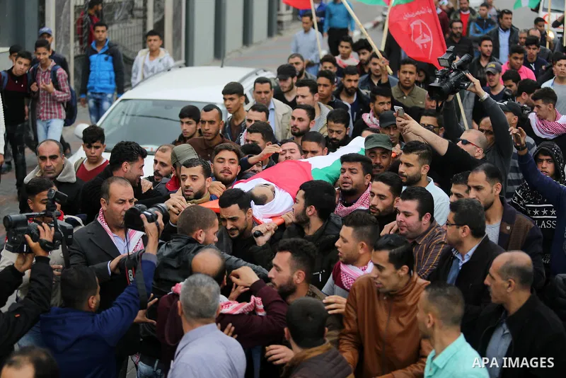 Mourners carry the body of Palestinian journalist Ahmed Abu Hussein, 24, who was died of his injuries sustained by Israeli security forces as he was covering demonstrations on the Gaza border since two weeks ago, during...