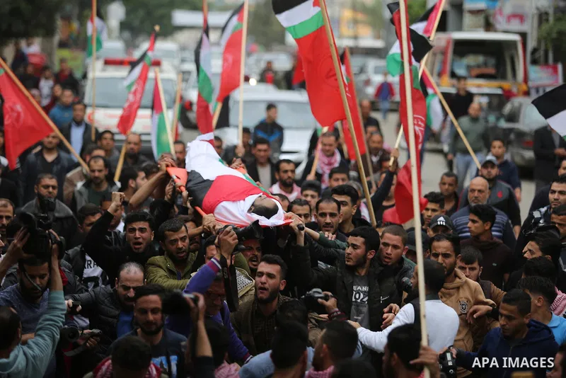 Mourners carry the body of Palestinian journalist Ahmed Abu Hussein, 24, who was died of his injuries sustained by Israeli security forces as he was covering demonstrations on the Gaza border since two weeks ago, during...