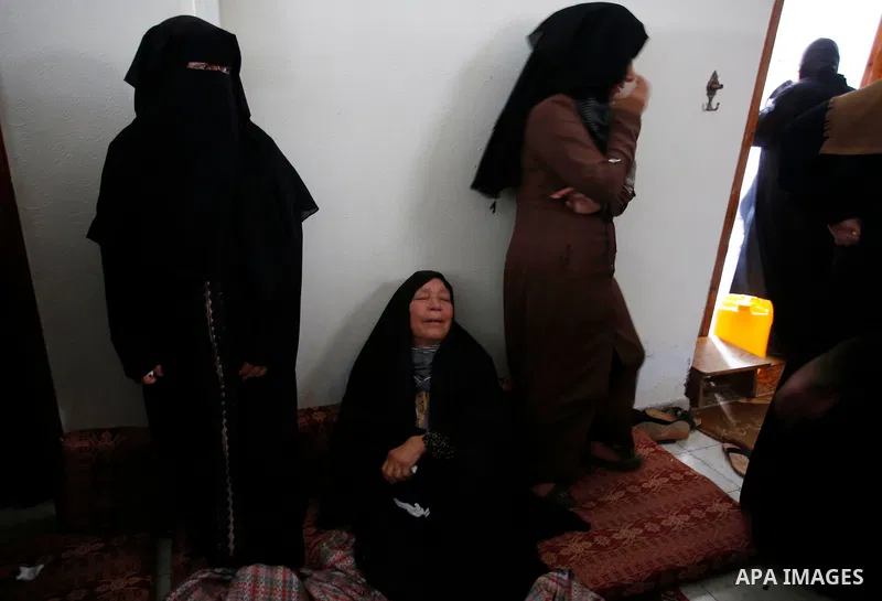 Palestinian women mourn over the body of 15-year-old Palestinian teenager Azzam Oweida who was died of his injuries sustained by Israeli security forces during clashes at the Israel-Gaza border, during his funeral in Kha...
