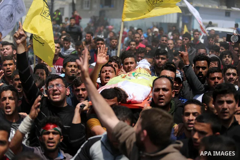Mourners carry the body of 15-year-old Palestinian teenager Azzam Oweida who was died of his injuries sustained by Israeli security forces during clashes at the Israel-Gaza border, during his funeral in Khan Yunis in the...