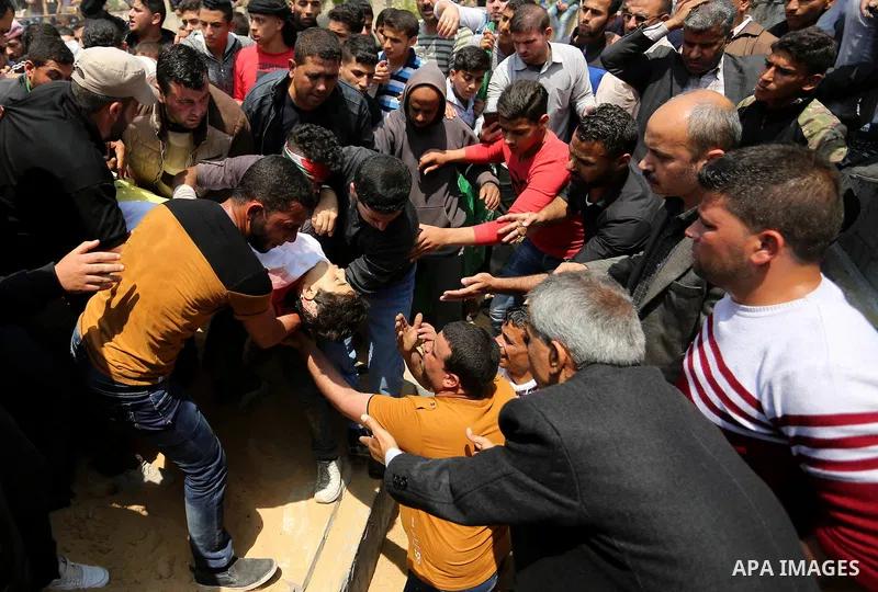 Mourners bury the body of 15-year-old Palestinian teenager Azzam Oweida who was died of his injuries sustained by Israeli security forces during clashes at the Israel-Gaza border, during his funeral in Khan Yunis in the...
