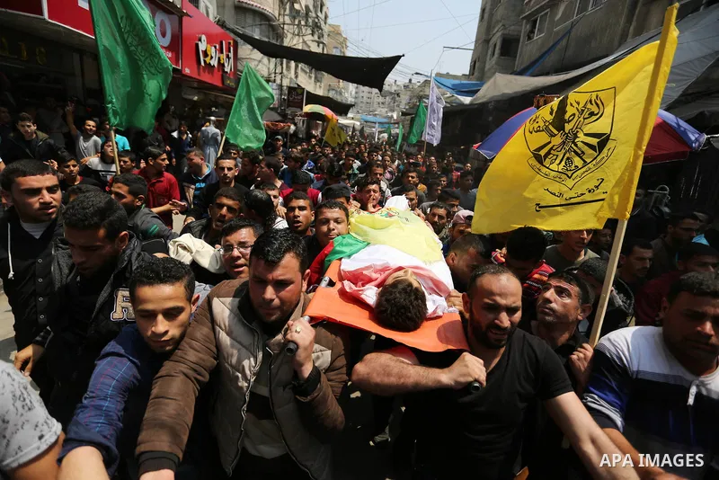 Mourners carry the body of 15-year-old Palestinian teenager Azzam Oweida who was died of his injuries sustained by Israeli security forces during clashes at the Israel-Gaza border, during his funeral in Khan Yunis in the...