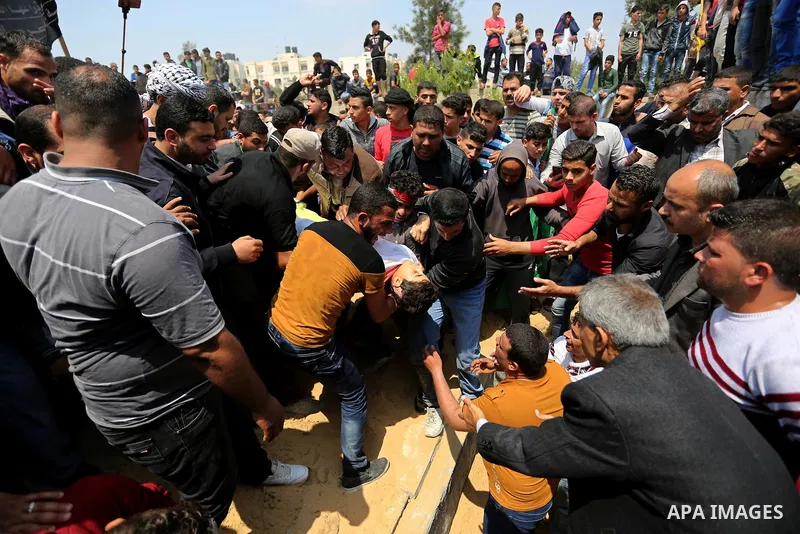 Mourners bury the body of 15-year-old Palestinian teenager Azzam Oweida who was died of his injuries sustained by Israeli security forces during clashes at the Israel-Gaza border, during his funeral in Khan Yunis in the...