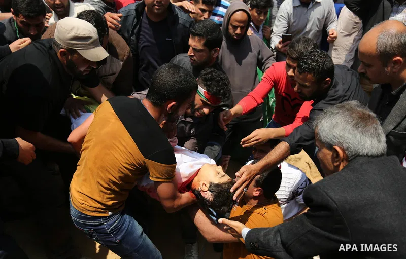 Mourners bury the body of 15-year-old Palestinian teenager Azzam Oweida who was died of his injuries sustained by Israeli security forces during clashes at the Israel-Gaza border, during his funeral in Khan Yunis in the...