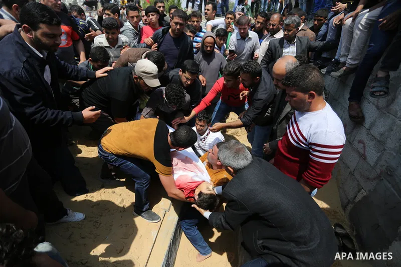 Mourners bury the body of 15-year-old Palestinian teenager Azzam Oweida who was died of his injuries sustained by Israeli security forces during clashes at the Israel-Gaza border, during his funeral in Khan Yunis in the...