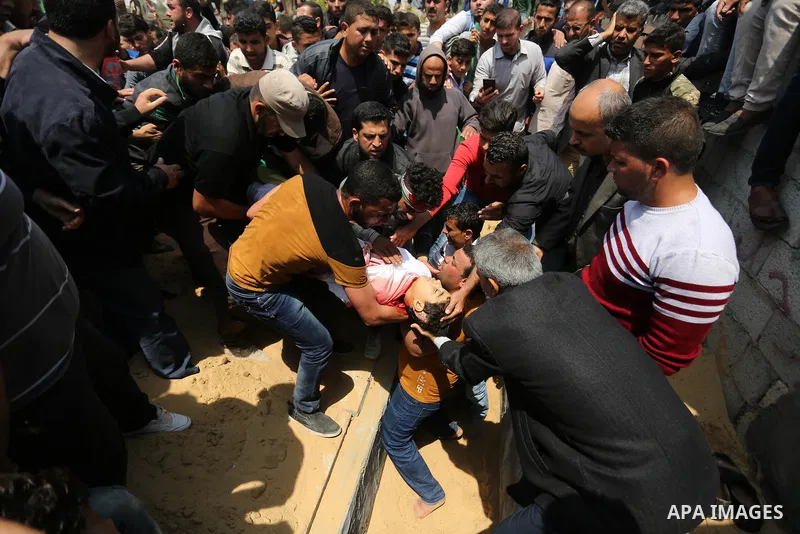 Mourners bury the body of 15-year-old Palestinian teenager Azzam Oweida who was died of his injuries sustained by Israeli security forces during clashes at the Israel-Gaza border, during his funeral in Khan Yunis in the...
