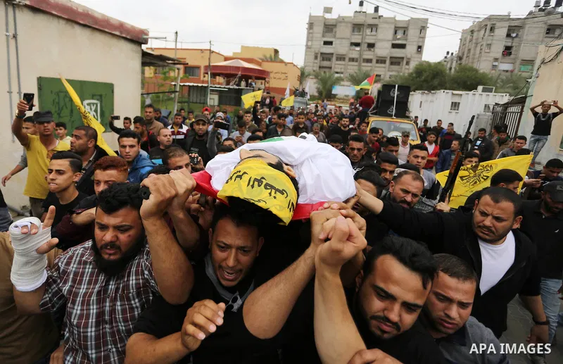 Mourners carry the body of Abdul Salam Bakr, 29, who was shot dead by Israeli security forces during clashes at the Israel-Gaza border, during his funeral in Khan Yunis in the southern Gaza Strip on April 28, 2018. Photo...