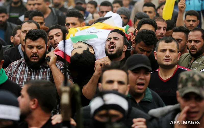 Mourners carry the body of Abdul Salam Bakr, 29, who was shot dead by Israeli security forces during clashes at the Israel-Gaza border, during his funeral in Khan Yunis in the southern Gaza Strip on April 28, 2018. Photo...