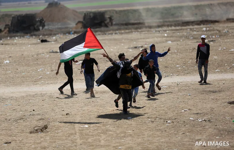 A Palestinian protester dressed as Bat Man waves Palestine flag during a protest demanding the right to return to their homeland, at the Israel-Gaza border in Khan Younis in the southern Gaza Strip, May 9, 2018. Photo by...