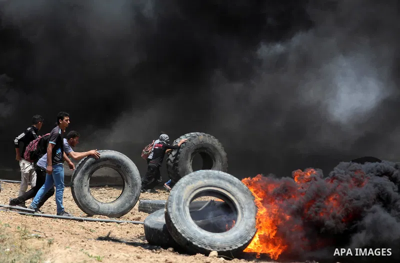 Palestinian protesters gather during clashes with Israeli security froces in a tent city protest where Palestinians demand the right to return to their homeland, on the occasion of the 70th anniversary of the "Nakba", an...