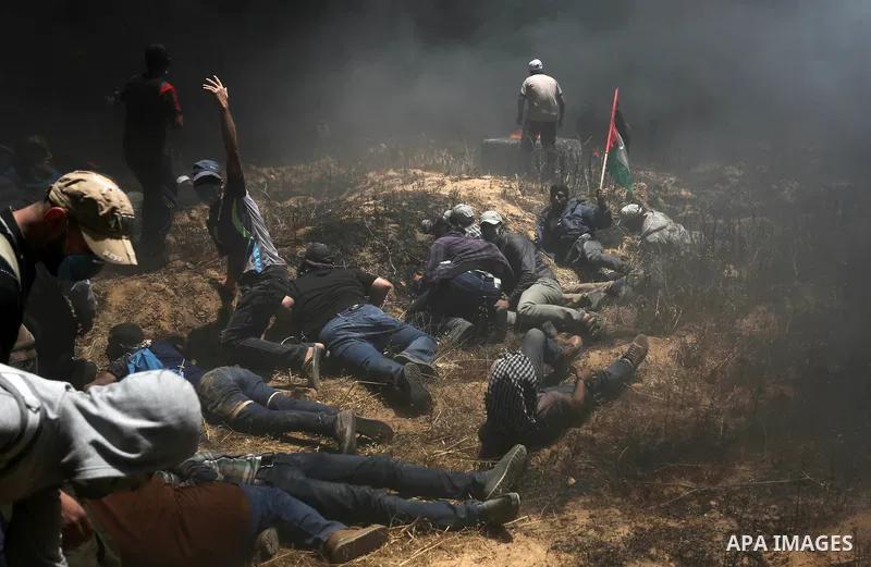 Palestinian protesters gather during clashes with Israeli security froces in a tent city protest where Palestinians demand the right to return to their homeland, on the occasion of the 70th anniversary of the "Nakba", an...
