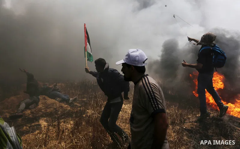 Palestinian protesters gather during clashes with Israeli security froces in a tent city protest where Palestinians demand the right to return to their homeland, on the occasion of the 70th anniversary of the "Nakba", an...
