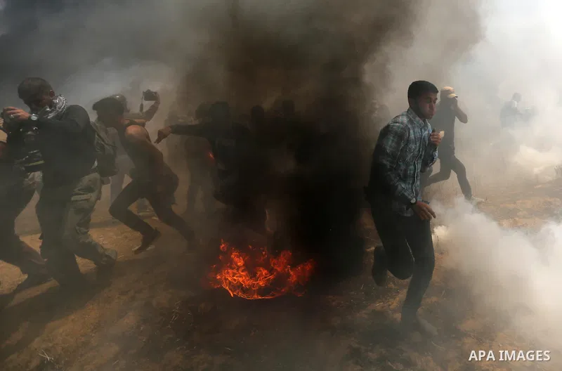 Palestinian protesters gather during clashes with Israeli security froces in a tent city protest where Palestinians demand the right to return to their homeland, on the occasion of the 70th anniversary of the "Nakba", an...