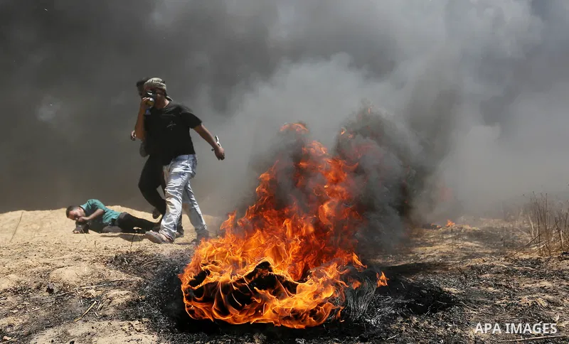 Palestinian protesters gather during clashes with Israeli security froces in a tent city protest where Palestinians demand the right to return to their homeland, on the occasion of the 70th anniversary of the "Nakba", an...