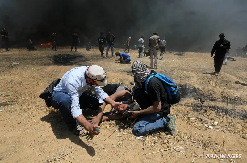 Palestinian protesters gather during clashes with Israeli security froces in a tent city protest where Palestinians demand the right to return to their homeland, on the occasion of the 70th anniversary of the "Nakba", an...