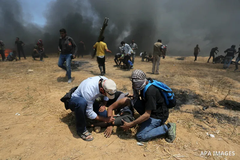 Palestinian protesters gather during clashes with Israeli security froces in a tent city protest where Palestinians demand the right to return to their homeland, on the occasion of the 70th anniversary of the "Nakba", an...