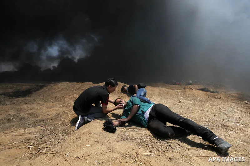 Palestinian protesters gather during clashes with Israeli security froces in a tent city protest where Palestinians demand the right to return to their homeland, on the occasion of the 70th anniversary of the "Nakba", an...