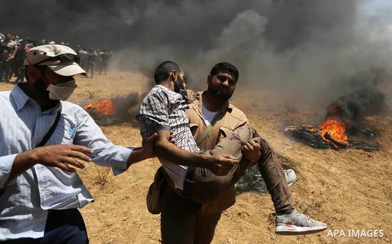 A wounded Palestinian protester is evacuated during clashes with Israeli security froces in a tent city protest where Palestinians demand the right to return to their homeland, on the occasion of the 70th anniversary of...