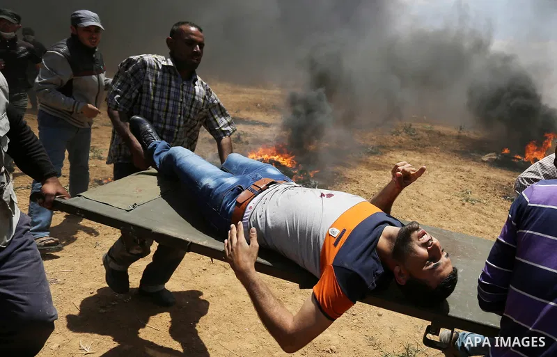 A wounded Palestinian protester is evacuated during clashes with Israeli security froces in a tent city protest where Palestinians demand the right to return to their homeland, on the occasion of the 70th anniversary of...