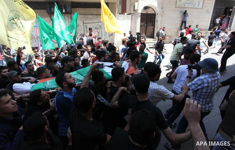 Mourners carry the body of Palestinian Yazan al-Tubasi, who was killed by Israeli troops during clashes in a tent city protest where Palestinians demand the right to return to their homeland, on the occasion of the 70th...