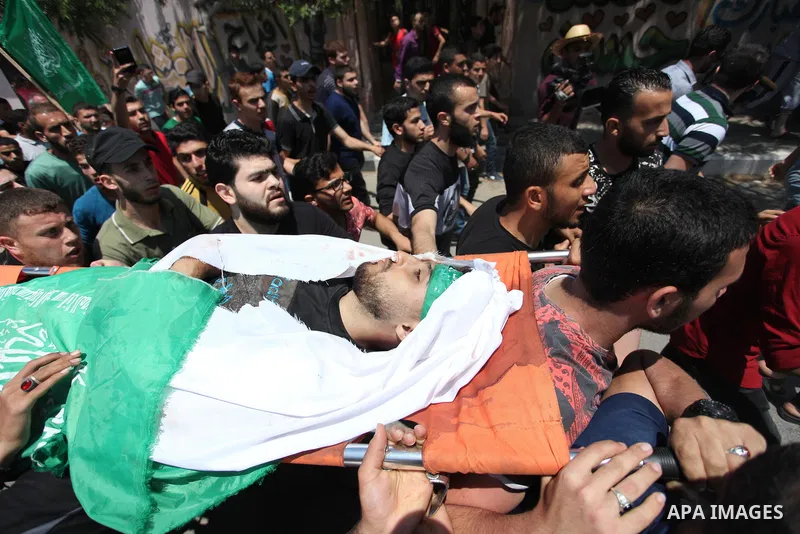 Mourners carry the body of Palestinian Yazan al-Tubasi, who was killed by Israeli troops during clashes in a tent city protest where Palestinians demand the right to return to their homeland, on the occasion of the 70th...