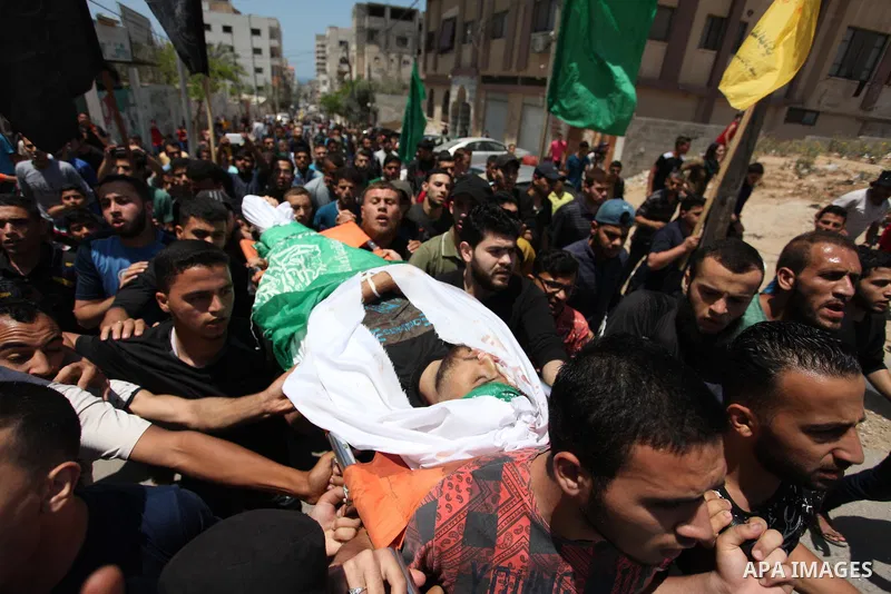 Mourners carry the body of Palestinian Yazan al-Tubasi, who was killed by Israeli troops during clashes in a tent city protest where Palestinians demand the right to return to their homeland, on the occasion of the 70th...