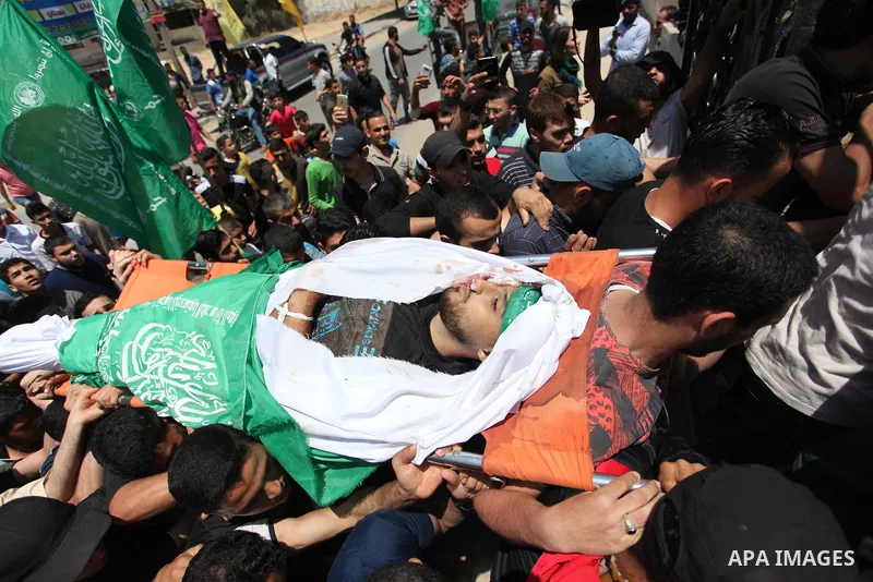 Mourners carry the body of Palestinian Yazan al-Tubasi, who was killed by Israeli troops during clashes in a tent city protest where Palestinians demand the right to return to their homeland, on the occasion of the 70th...