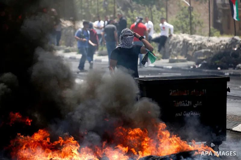 Palestinian protesters gather during clashes with Israeli security forces following a protest against U.S. embassy move to Jerusalem and on the occasion of the 70th anniversary of the "Nakba" or "catastrophe", in the Wes...