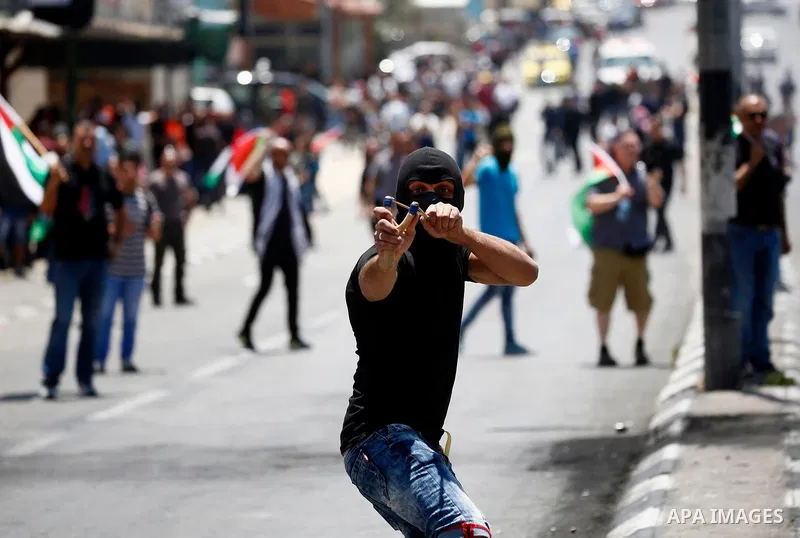 Palestinian protesters gather during clashes with Israeli security forces following a protest against U.S. embassy move to Jerusalem and on the occasion of the 70th anniversary of the "Nakba" or "catastrophe", in the Wes...