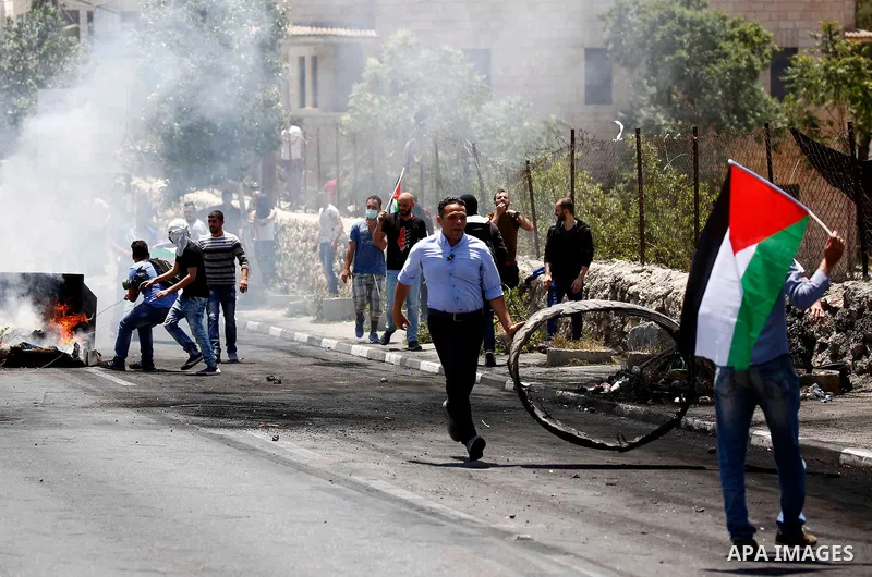 Palestinian protesters gather during clashes with Israeli security forces following a protest against U.S. embassy move to Jerusalem and on the occasion of the 70th anniversary of the "Nakba" or "catastrophe", in the Wes...