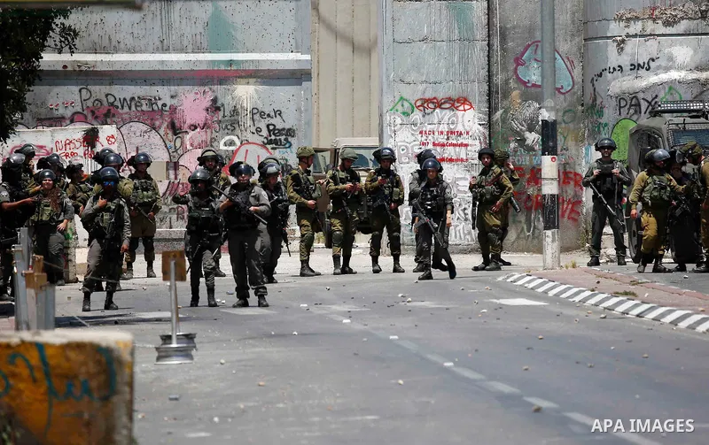Israeli security forces take position during clashes with Palestinian protesters following a protest against U.S. embassy move to Jerusalem and on the occasion of the 70th anniversary of the "Nakba" or "catastrophe", in...