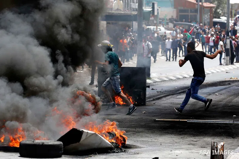 Palestinian protesters gather during clashes with Israeli security forces following a protest against U.S. embassy move to Jerusalem and on the occasion of the 70th anniversary of the "Nakba" or "catastrophe", in the Wes...