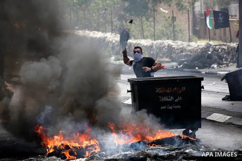 Palestinian protesters gather during clashes with Israeli security forces following a protest against U.S. embassy move to Jerusalem and on the occasion of the 70th anniversary of the "Nakba" or "catastrophe", in the Wes...