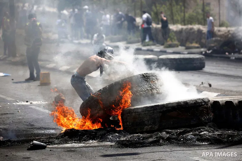 Palestinian protesters gather during clashes with Israeli security forces following a protest against U.S. embassy move to Jerusalem and on the occasion of the 70th anniversary of the "Nakba" or "catastrophe", in the Wes...