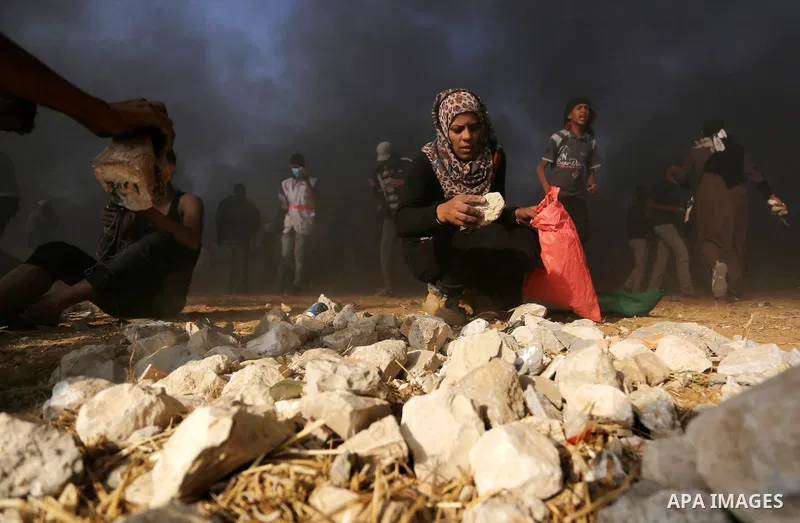 Palestinian protesters gather during clashes with Israeli security froces in a tent city protest where Palestinians demand the right to return to their homeland, on the occasion of the 70th anniversary of the "Nakba", an...