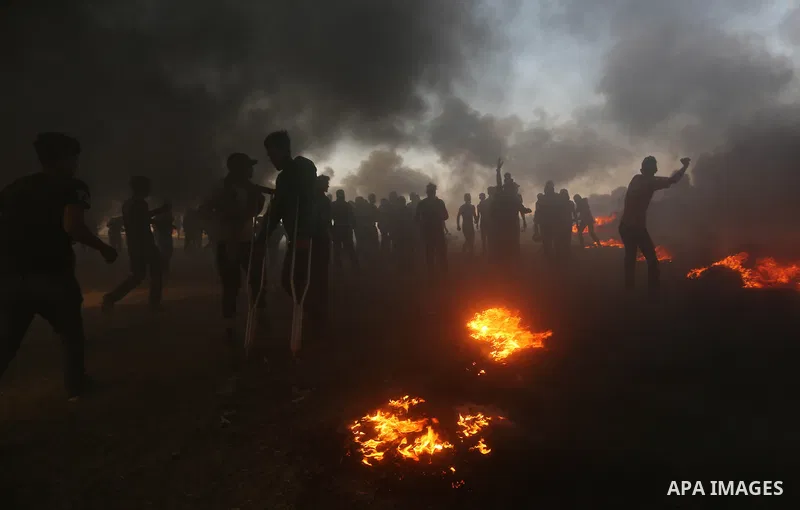 Palestinian protesters gather during clashes with Israeli security froces in a tent city protest where Palestinians demand the right to return to their homeland, on the occasion of the 70th anniversary of the "Nakba", an...