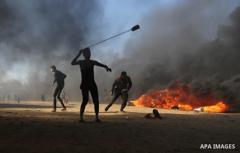 Palestinian protesters gather during clashes with Israeli security froces in a tent city protest where Palestinians demand the right to return to their homeland, on the occasion of the 70th anniversary of the "Nakba", an...