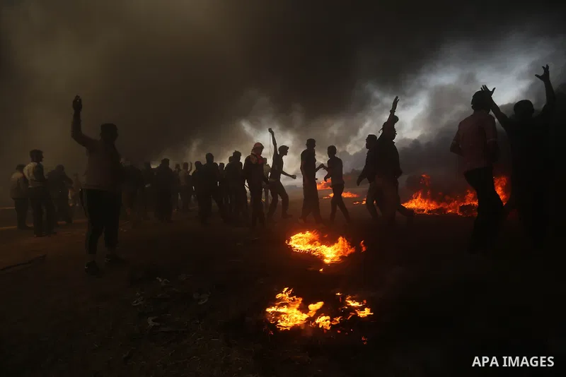 Palestinian protesters gather during clashes with Israeli security froces in a tent city protest where Palestinians demand the right to return to their homeland, on the occasion of the 70th anniversary of the "Nakba", an...