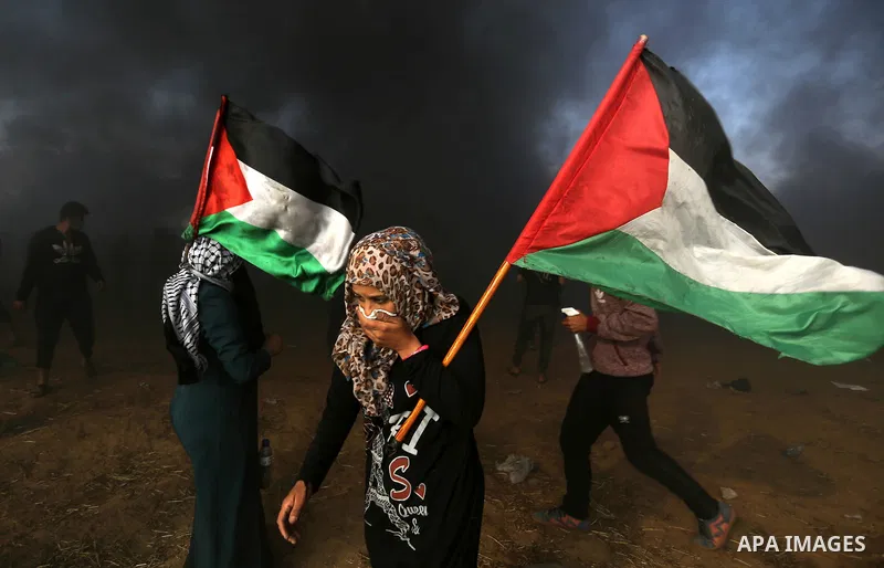 Palestinian protesters gather during clashes with Israeli security froces in a tent city protest where Palestinians demand the right to return to their homeland, on the occasion of the 70th anniversary of the "Nakba", an...
