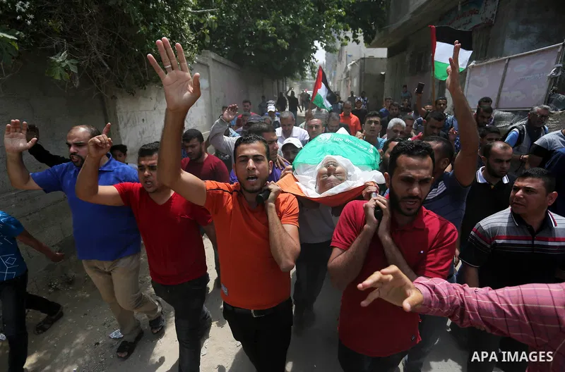 Mourners carry the body of Palestinian Nasser Ghorab, 51, who was killed the day before during clashes with Israeli troops along the border with Israel in a tent city protest where Palestinians demand the right to return...