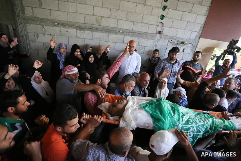 Mourners carry the body of Palestinian Nasser Ghorab, 51, who was killed the day before during clashes with Israeli troops along the border with Israel in a tent city protest where Palestinians demand the right to return...