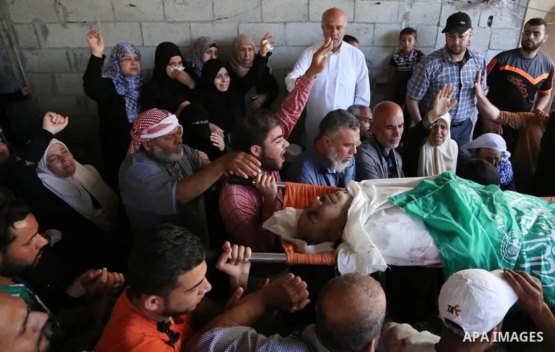 Mourners carry the body of Palestinian Nasser Ghorab, 51, who was killed the day before during clashes with Israeli troops along the border with Israel in a tent city protest where Palestinians demand the right to return...