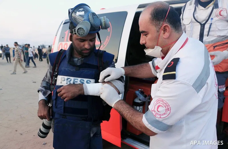 A Palestinian photographer, Ashraf Amra, receives treatment as he covering a demonstration where Palestinians demand the right to return to their homeland, on the occasion of the 70th anniversary of the "Nakba", and agai...
