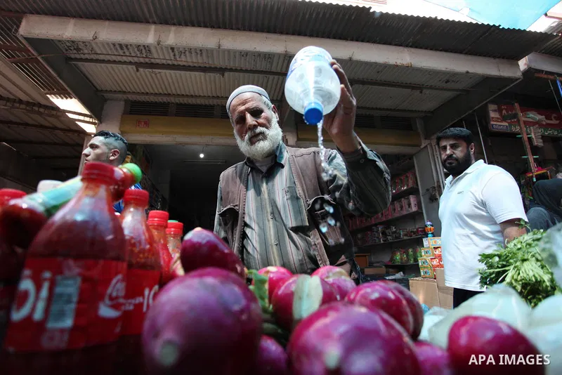 A Palestinian vendor sells vegetables at a market ahead of the Muslim holy fasting month of Ramadan, in Gaza city, on May 16, 2018 as the faithful prepare to start fasting. Photo by Mahmoud Ajour
