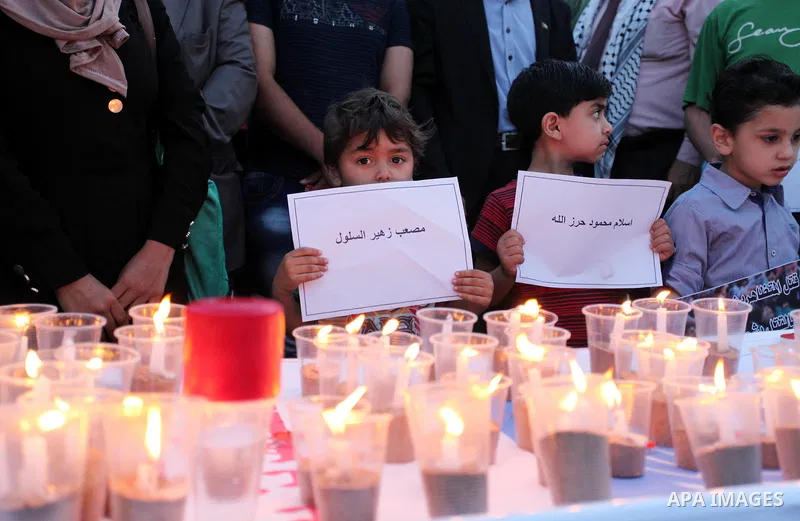 Palestinians light candles during a protest two days after at least 60 Palestinians were killed and 2,400 were injured including children, were shot and killed by Israeli soldiers as they gathered to demonstrate along th...